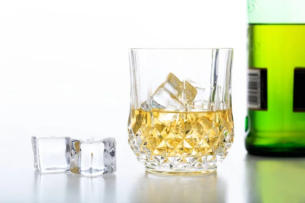Glas Whisky und Eis auf weißem Hintergrund — Stockfoto