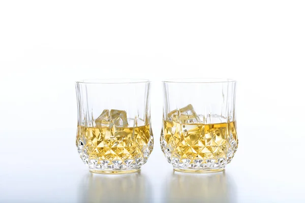 Стаканы виски и льда на белом фоне — стоковое фото