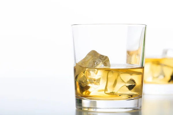 Glasses of whiskey and ice on white background — Stock Photo, Image