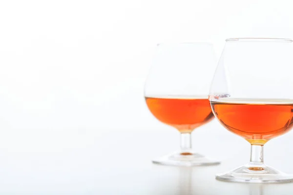 Två cognac glasögon på vit bakgrund — Stockfoto