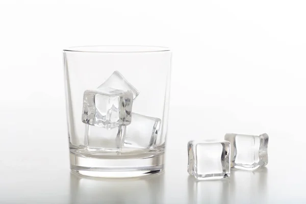 Κρυστάλλινο ποτήρι ουίσκι και το πάγο σε λευκό φόντο — Φωτογραφία Αρχείου