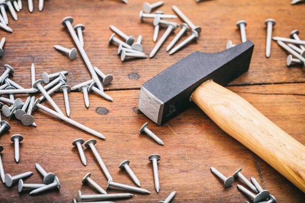 молоток и гвозди на деревянном фоне