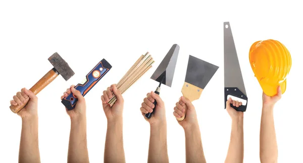 Mãos segurando ferramentas no fundo branco — Fotografia de Stock