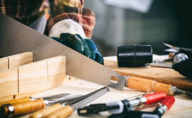 Bir el testeresi elinde marangoz