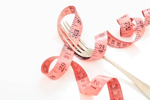 Measuring tape and a fork on white background — Stock Photo, Image