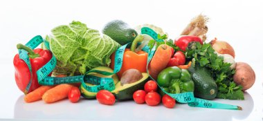 Çeşitli sebze ve beyaz arka plan üzerinde ölçü birimi teyp