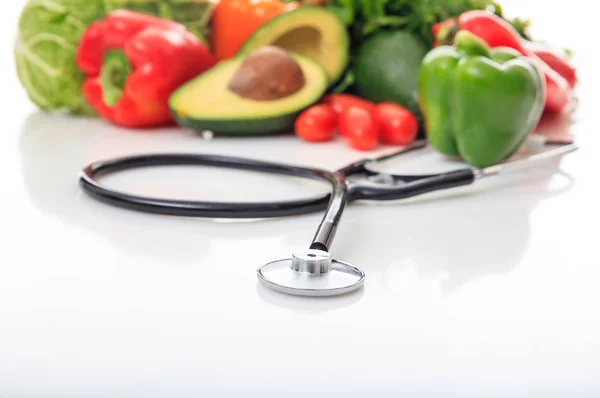 Variety of vegetables and stethoscope on white background — Stock Photo, Image