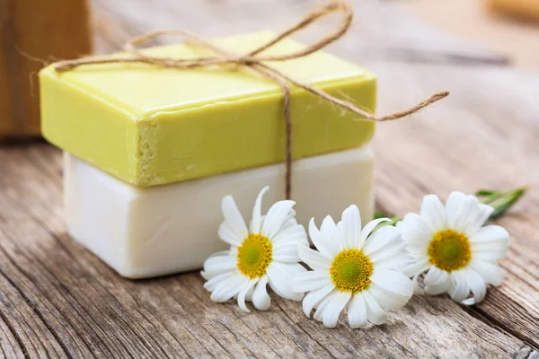 Handmade soap bars and chamomile on wooden background — Stock Photo, Image