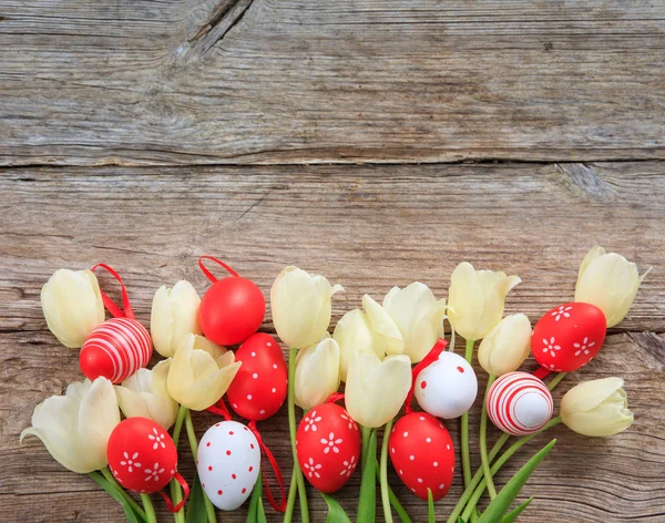 Ovos de Páscoa e tulipas em fundo de madeira e espaço de cópia — Fotografia de Stock