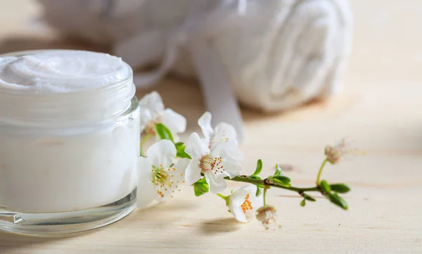 Crème hydratante et fleurs d'amande sur fond en bois — Photo