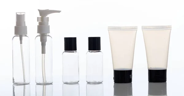 Tom transparent kosmetika flaskor och tuber på vit bakgrund — Stockfoto