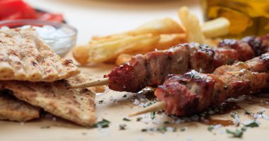 Grilled meat skewers on a table clipart