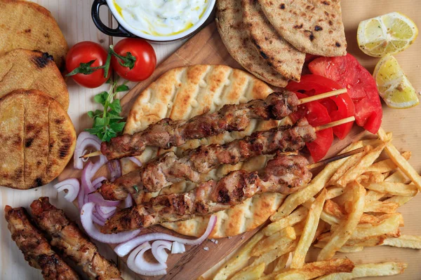 Gegrilde vleesspiesen op een pita-brood - bovenaanzicht — Stockfoto