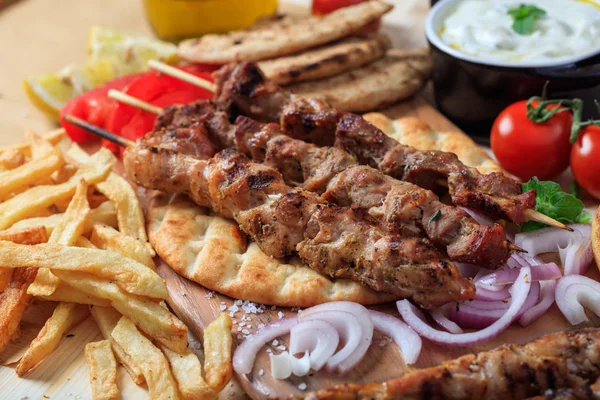 Espetos de carne grelhados em um pão de pita — Fotografia de Stock