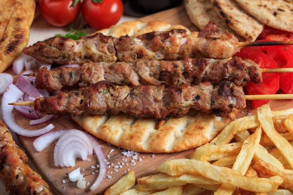 Espetos de carne grelhados em um pão de pita — Fotografia de Stock