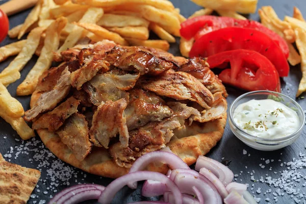 Греческое блюдо гироскопа на черном блюде — стоковое фото