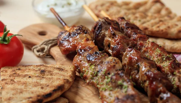 Grilled meat skewers on a wooden surface — Stock Photo, Image