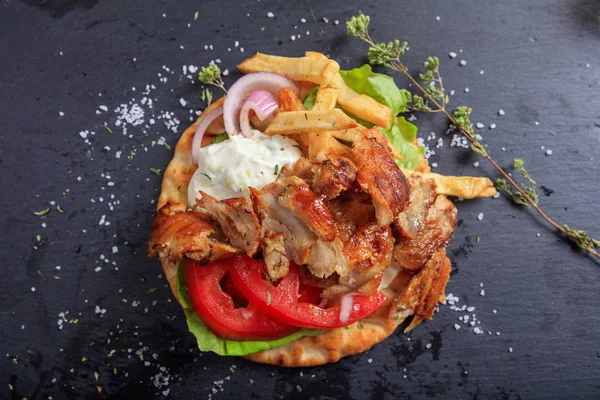 Griekse gyros schotel op een zwarte schotel - bovenaanzicht — Stockfoto