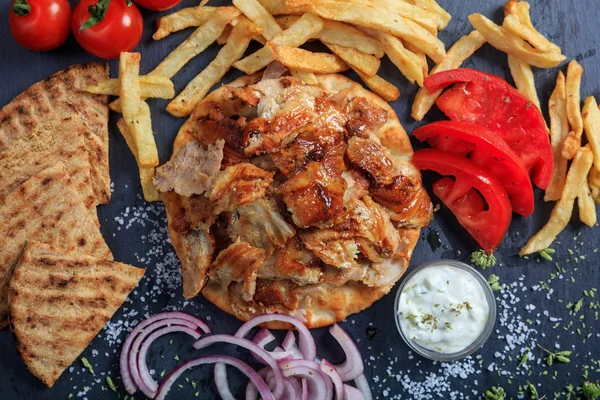 Hidangan gyros Yunani pada piring hitam-top view — Stok Foto