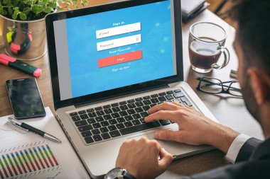 Adam bir dizüstü bilgisayar - bilgisayar ekranında giriş ile iş yerinde