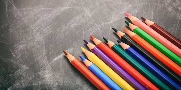 Цветные карандаши на черной доске — стоковое фото