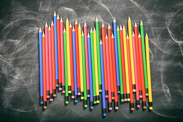 Színes ceruza, egy fekete tábla — Stock Fotó