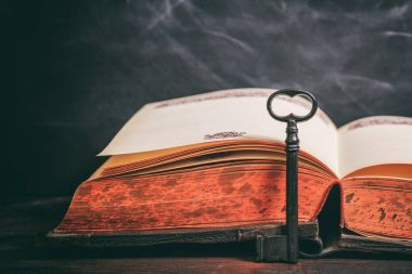 Anahtar ilgili ahşap arka plan bir vintage kitap