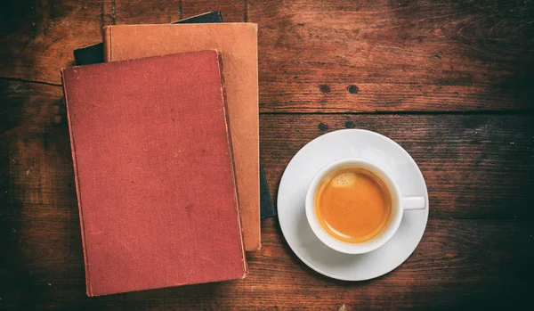 Винтажные книги и чашка кофе на деревянном фоне — стоковое фото