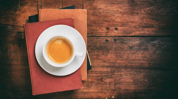 Винтажные книги и чашка кофе на деревянном фоне — стоковое фото