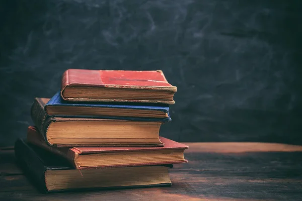 Vintage books stack på blackboard bakgrund — Stockfoto