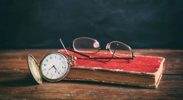 Libro vintage y reloj de bolsillo sobre fondo oscuro —  Fotos de Stock