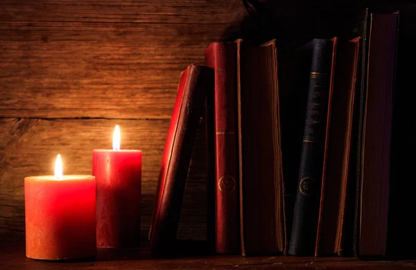 Vintage books and candles on dark background — Stock Photo, Image