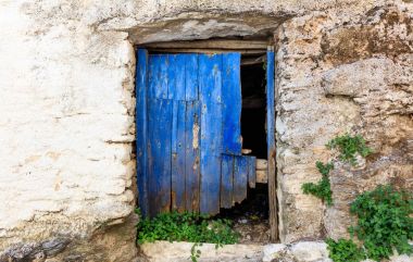Taştan bir duvar üzerinde eski ahşap kapı