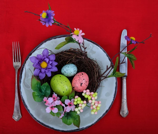 Decoração de Páscoa em uma chapa na toalha de mesa vermelha — Fotografia de Stock