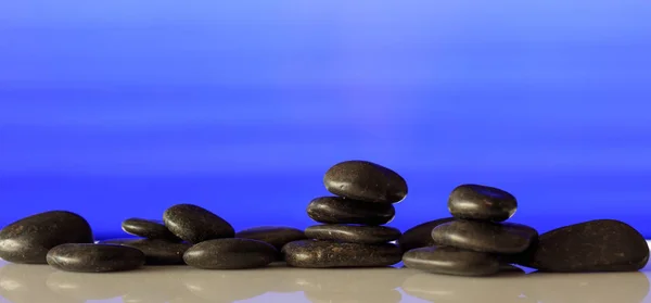 Zen stones wiersz na niebieskim tle — Zdjęcie stockowe