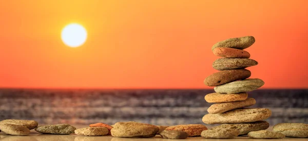 Zen stenen stack op de achtergrond van de zee bij zonsondergang — Stockfoto