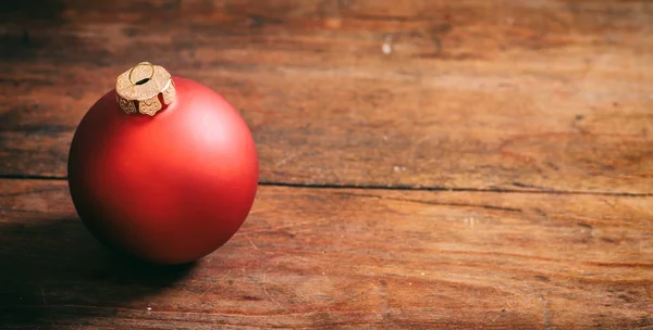 Červená vánoční koule na dřevěné pozadí — Stock fotografie