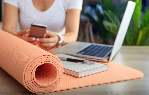 Mulher e um tapete de exercícios em um fundo de escritório — Fotografia de Stock