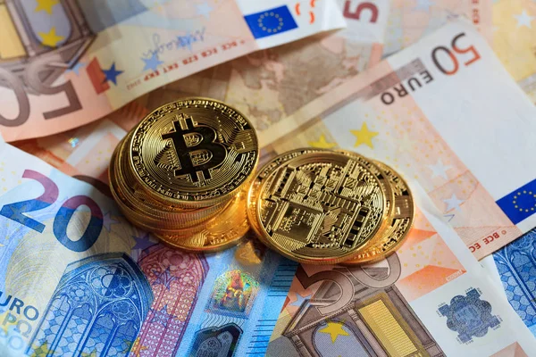 Empilhamento de Bitcoins no fundo das notas de euro — Fotografia de Stock