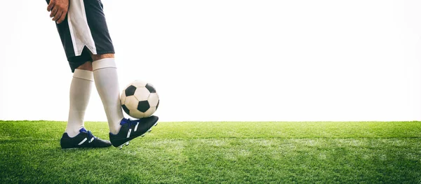 Человек управляет футбольным мячом на траве — стоковое фото