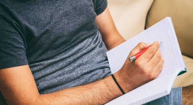 Evde çalışma alanı. Yazma, bir koltukta oturan öğrenci