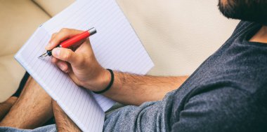 Evde çalışma alanı. Yazma, bir koltukta oturan öğrenci