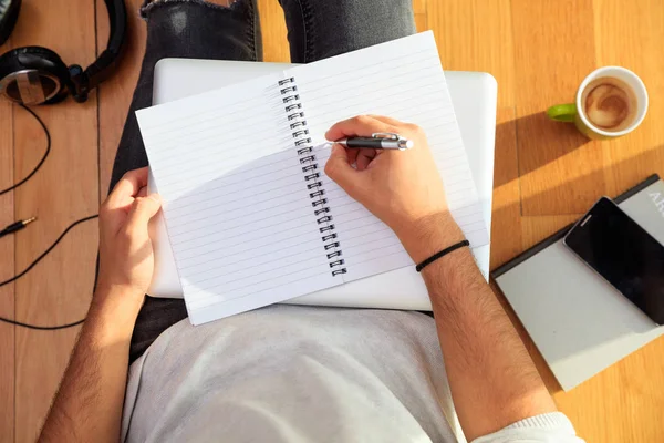 Arbetsytan hemma. Studenten skriva, sitter på golvet. — Stockfoto