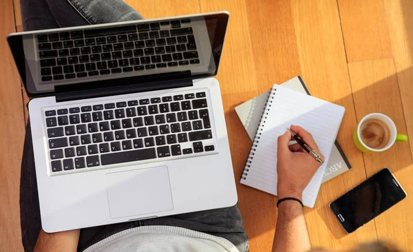 Arbetsytan hemma. Studenten arbetar med en laptop på golvet — Stockfoto