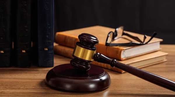 Rechter hamer op een houten bureau, recht boeken achtergrond — Stockfoto