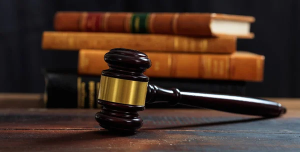 Rechter hamer op een houten bureau, recht boeken achtergrond — Stockfoto