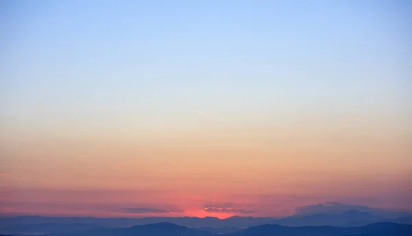 Hermoso atardecer en el cielo sobre montañas fondo . — Foto de Stock