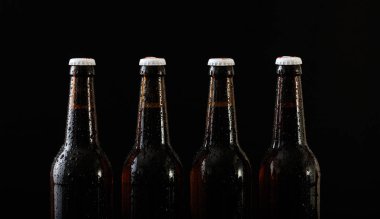 Siyah arka plan üzerine izole dört bira şişeleri closeup