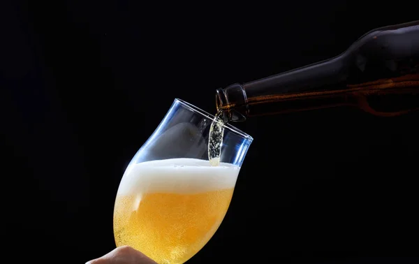 Versare la birra in un primo piano di vetro, sfondo nero — Foto Stock