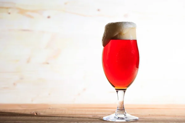 Um copo de cerveja vermelha em uma mesa de madeira, espaço de cópia — Fotografia de Stock
